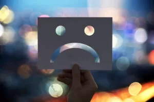 Ilustração conceitual representando por que sua empresa de formatura perde clientes no atendimento, com uma expressão triste simbolizando insatisfação do cliente.