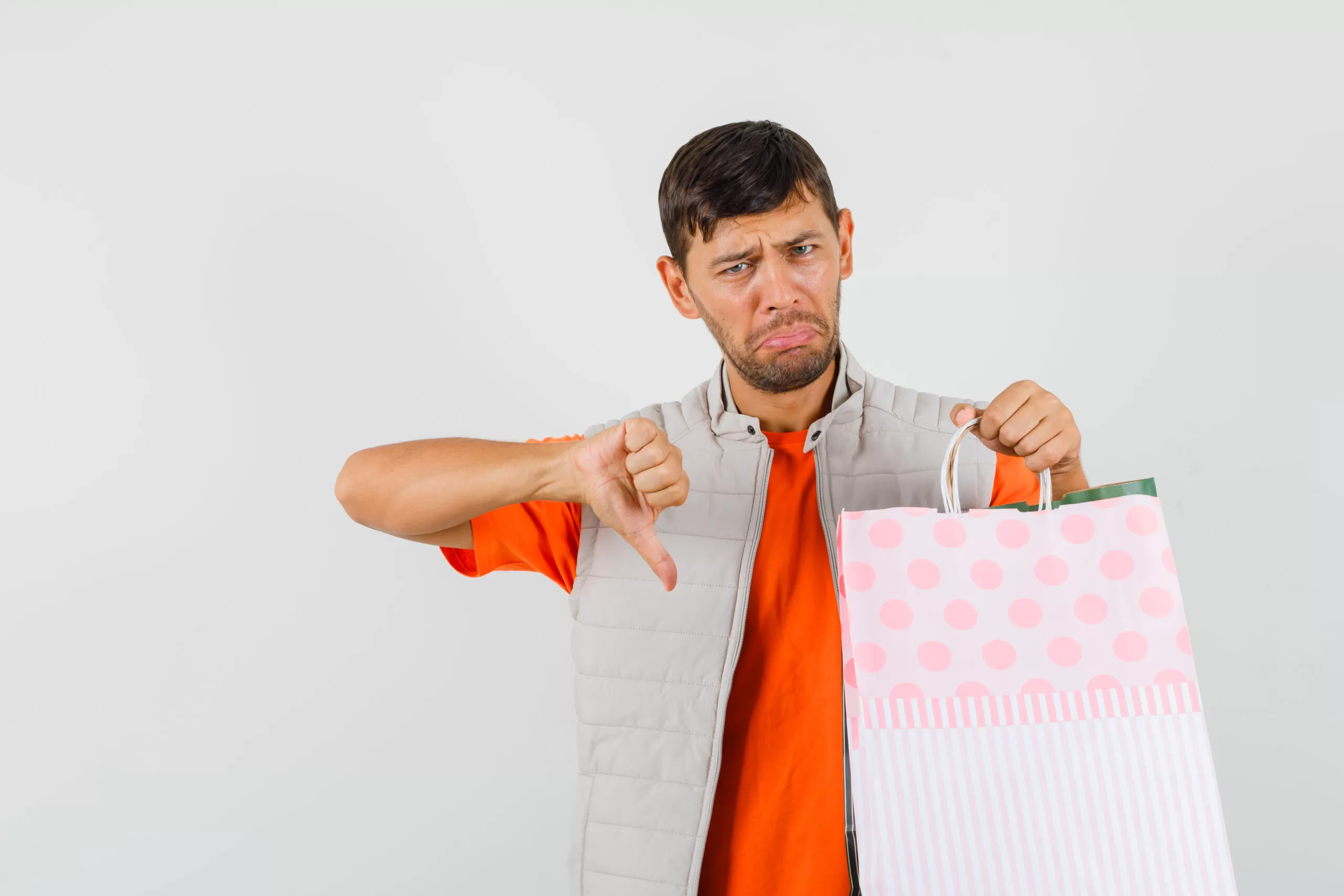 Homem desapontado segurando sacola de compras, representando erros que fazem você perder vendas ao anunciar um imóvel.