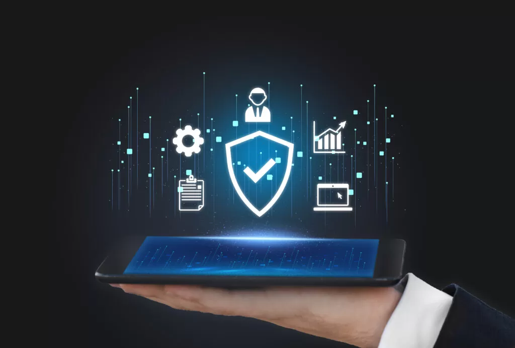 Mão segurando um tablet com ícones digitais flutuantes representando segurança, crescimento, e eficiência, destacando a importância da transformação digital no comércio.