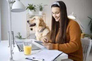 5 Estratégias para Fidelizar Clientes no Pet Shop – Empresária trabalha com um cachorro no colo, simbolizando atendimento de qualidade e fidelização.