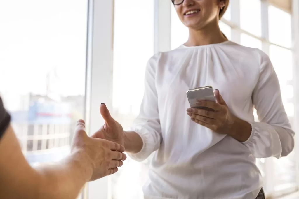 5 Estratégias para Fidelizar Clientes no Pet Shop – Cliente cumprimenta atendente com um aperto de mão, simbolizando confiança e fidelização no pet shop.